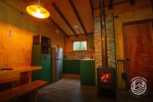 a kitchen with a stove in the middle of a room at Cabañas Leufu in Futaleufu