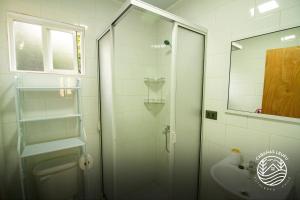 a bathroom with a glass shower and a sink at Cabañas Leufu in Futaleufu