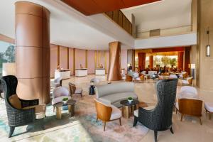 a lobby of a hotel with chairs and tables at Amari Vientiane in Vientiane