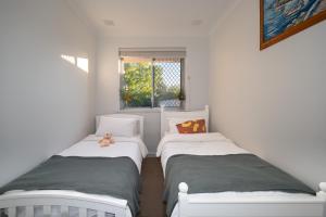 zwei Einzelbetten in einem Zimmer mit Fenster in der Unterkunft B1 AirportHaven - Free Parking & Modern Comfort in Perth