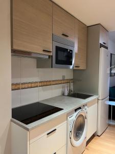 a kitchen with a washing machine and a microwave at Visita Zaragoza in Zaragoza