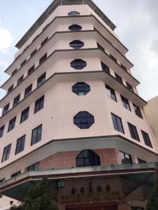 a tall white building with windows at Golden Star Hotel in Singapore