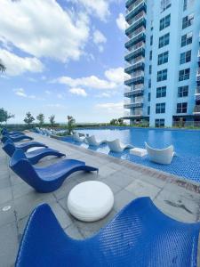 a row of blue chairs next to a swimming pool at Ultra Luxury 1BR near Solaire & Okada in Manila