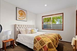 a bedroom with a bed and a window at Fabulous Lake Front House-Private lake access in Rotorua