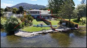 an aerial view of a house in the water at Fabulous Lake Front House-Private lake access in Rotorua