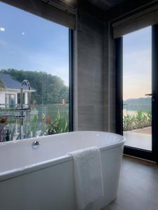 a white bath tub in a room with a large window at Lamori Resort & Spa in Thanh Hóa