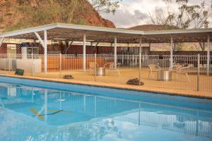 a swimming pool with a pavilion and chairs around it at Arkaroola Wilderness Sanctuary in Arkaroola