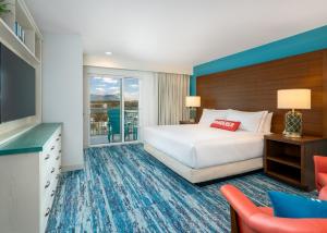 a hotel room with a bed and a television at Compass by Margaritaville Hotel Pigeon Forge in Pigeon Forge