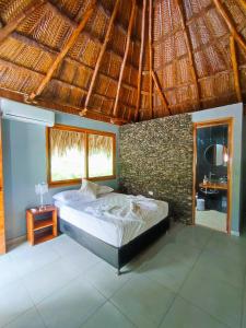 a bedroom with a bed in a straw roof at Colibri Parque Tayrona Dentro del Parque Nacional Tayrona in El Zaino