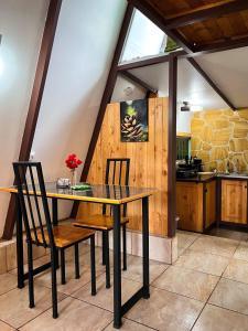 a dining room with a table and two chairs at Cabaña Azalea en Santa María de Dota in Santa María