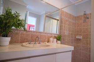 un bagno con lavandino e specchio di Airport 6BR Haven - Quiet Yard & AC a Perth Altre 44 foto