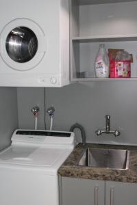 a kitchen with a sink and a washing machine at The Cameron Bothy in Queenstown +14 photos