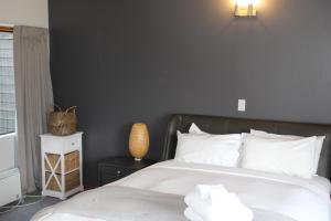 a bedroom with a bed with a black wall at The Cameron Bothy in Queenstown