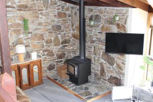a stone wall with a stove in a living room at The Cameron Bothy in Queenstown