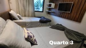 a hotel room with two beds and a mirror at Manhattan Riviera Beach in Aquiraz +57 photos