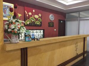 a reception counter with a vase of flowers on it at Ingfah Mountainview in Hat Yai +12 photos