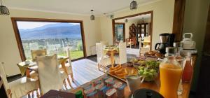 a dining room with a table with food and orange juice at Hotel HORSTMEYER in Cochrane