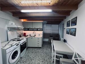 a kitchen with a stove and a sink and a table at Alfeios cozy stays - Attic in Pyrgos