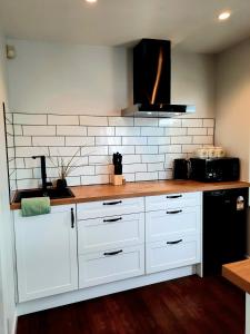 una cucina con armadi bianchi e piano di lavoro di Whakatā Place a Motueka