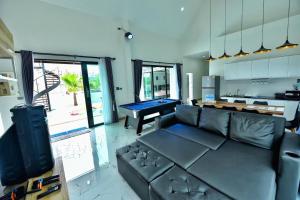a living room with a couch and a pool table at Level UP pool villa Rayong in Rayong