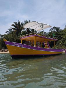 a colorful boat is sitting in the water at Barco Sorriso Paraty in Paraty