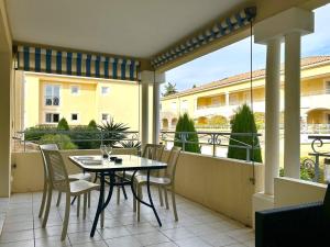 un patio avec une table et des chaises sur un balcon dans l'établissement Appartement climatisé 2 pièces avec terrasse et parking au Lavandou - FR-1-251-854, au Lavandou