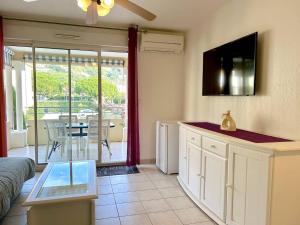 Il comprend un salon avec une cuisine et une vue sur un patio. dans l'établissement Appartement climatisé 2 pièces avec terrasse et parking au Lavandou - FR-1-251-854, au Lavandou