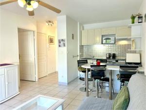 une cuisine et un salon avec une table et des chaises dans l'établissement Appartement climatisé 2 pièces avec terrasse et parking au Lavandou - FR-1-251-854, au Lavandou 7 autres photos