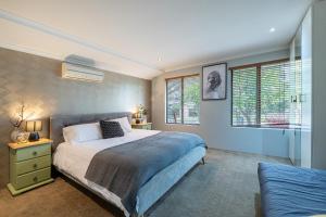 une chambre avec un lit, un canapé et des fenêtres dans l'établissement Airport 5BR Haven - Full Kitchen & Tranquil, à Perth