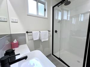 ein weißes Badezimmer mit Dusche und Waschbecken in der Unterkunft Karri Aura in Denmark + 30 Fotos
