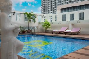 une piscine avec une statue à côté d'un bâtiment dans l'établissement Bonjour Nha Trang Hotel, à Nha Trang