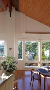 a living room with a table and chairs and windows at Amazing Getaway Oceanview with treehouse feel in Manchester