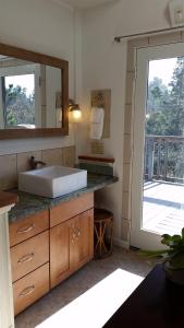 a bathroom with a sink and a large mirror at Amazing Getaway Oceanview with treehouse feel in Manchester