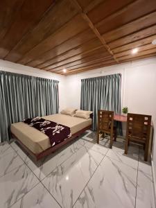 バガモンにあるVerdant peaks Homestayのベッドと机のある寝室
