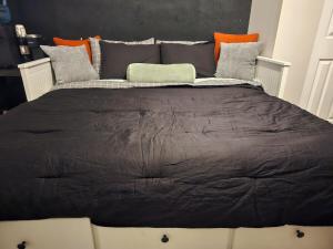 a large bed with a black comforter in a room at Tranquil studio oasis in Minneapolis