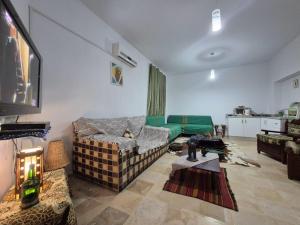 a living room with a couch and a tv at Maison hôte Dar Traki in Tozeur +23 photos