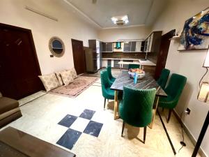 Una sala de estar con una mesa y sillas verdes. en 2 rooms with lounge appartment, en Karachi 16 fotos más