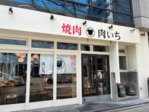 un magasin à l'avant d'un bâtiment avec des panneaux. dans l'établissement 駅南うちやまビルNi, à Fukuoka