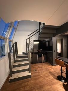 a living room with a staircase and a television at Loft Duplex com Hidromassagem in Florianópolis