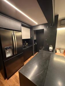 a kitchen with stainless steel appliances and a black counter top at Loft Duplex com Hidromassagem in Florianópolis