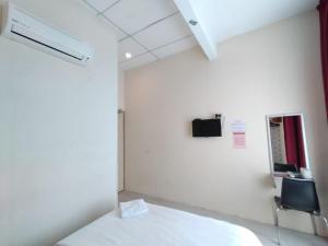 a room with a bed and a chair and a mirror at Hotel Bestari in Malacca