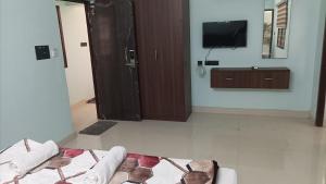 un soggiorno con TV e divano di Tru Comfort a Pondicherry