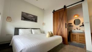 a bedroom with a white bed and a sink at Jenna in Koh Phangan