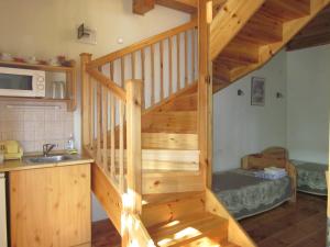 eine Holztreppe in einer Küche mit einem Waschbecken in der Unterkunft Bozsoki Pihenő in Bozsok