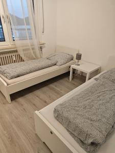 Work and Stay Plettenberg 90 Qm 7 Betten 3 Schlafzimmer mit Balkon und Kraftraum 44 oben في بليتنبرغ: غرفة نوم بها سريرين وطاولة ونافذة +76 صورة