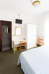 una camera con letto, scrivania e tavolo di Hotel Krizman a Monrupino