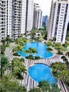 ジョホールバルにあるDeluxe 3 Bedroom Garden Viewのヤシの木と建物が並ぶ2つのプールの空中風景 +66枚の写真