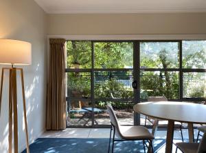 a living room with a table and chairs and a large window at Saxton Lodge in Nelson