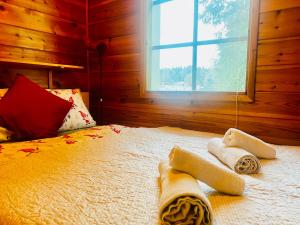 a bedroom with a bed with towels on it at Countryside riverside cabin for both winter and summer in Janakkala