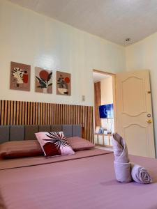 a bedroom with two beds and a persons feet on a bed at AisG Homestay Tres -Fully Furnished Shared Homestay FREE NETFLIX-3mins to Airport in Puerto Princesa City